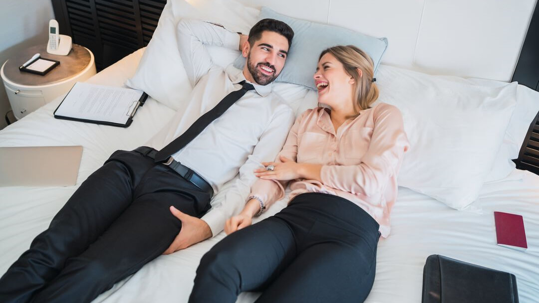 two professionals in a hotel room possibly on a bleisure trip as it is an increasing travel trend