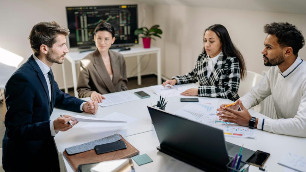 4 people meeting to discuss how to propose a hotel technology solution to their CFO