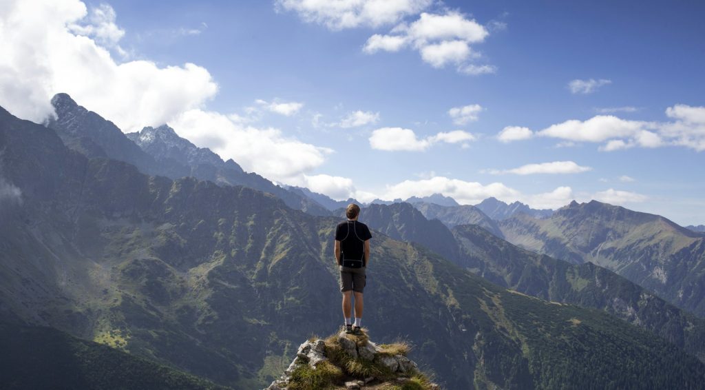 a person standing on their own looking out over a mountain range illustrating the predicted growth of solo travelers in 2026 and the importance for hotels to develop marketing strategies targeted at this segment