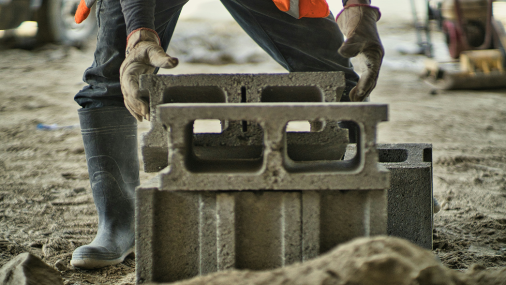 person laying foundation blocks in the same way hotels need to build better base business through smart contracting